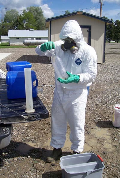 Figure 3. Outdoor photo of person in a full PPE suit, mixing chemicals.